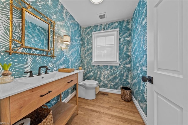 bathroom with vanity, toilet, and wood-type flooring