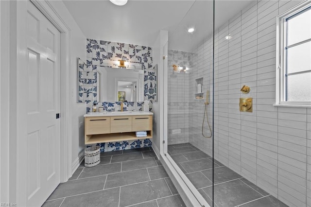 bathroom with tile patterned floors, vanity, and tiled shower