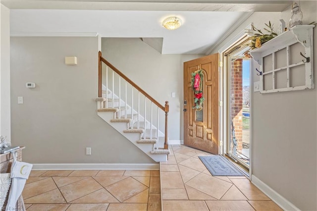 entryway with crown molding and light tile patterned flooring