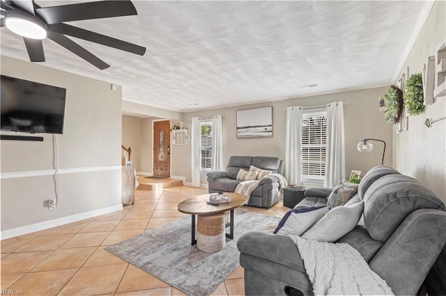 tiled living room featuring ceiling fan and ornamental molding