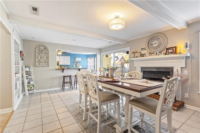 tiled dining space with beam ceiling, ornamental molding, and built in shelves