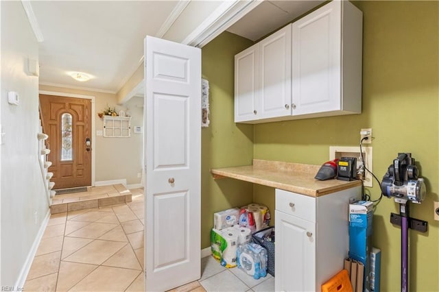 clothes washing area with crown molding, light tile patterned flooring, and washer hookup