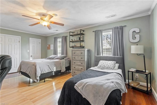 bedroom featuring hardwood / wood-style flooring, ceiling fan, and crown molding