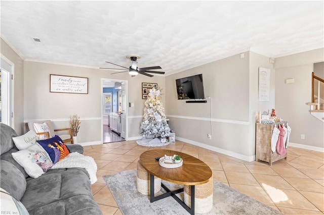 tiled living room featuring ceiling fan and ornamental molding