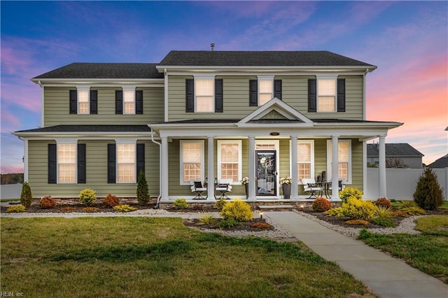 view of front of house with a porch and a lawn