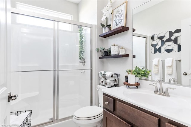 bathroom with toilet, vanity, and walk in shower