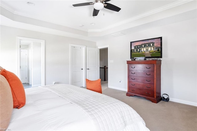 carpeted bedroom featuring a raised ceiling, ceiling fan, and crown molding