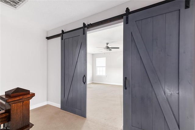 interior space featuring light carpet and a barn door