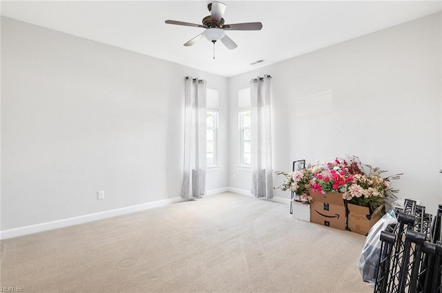 interior space featuring ceiling fan and light colored carpet