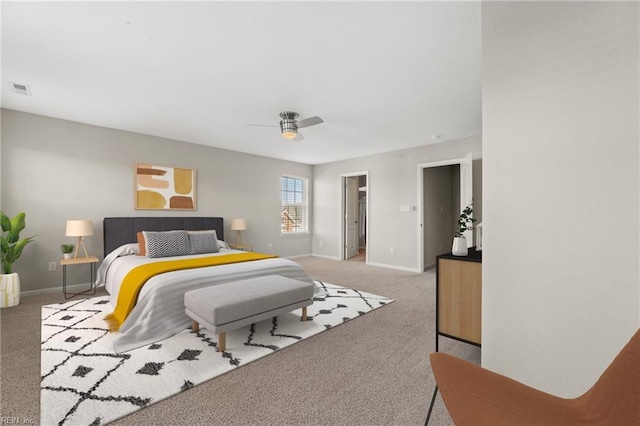 carpeted bedroom featuring ceiling fan, a walk in closet, and a closet