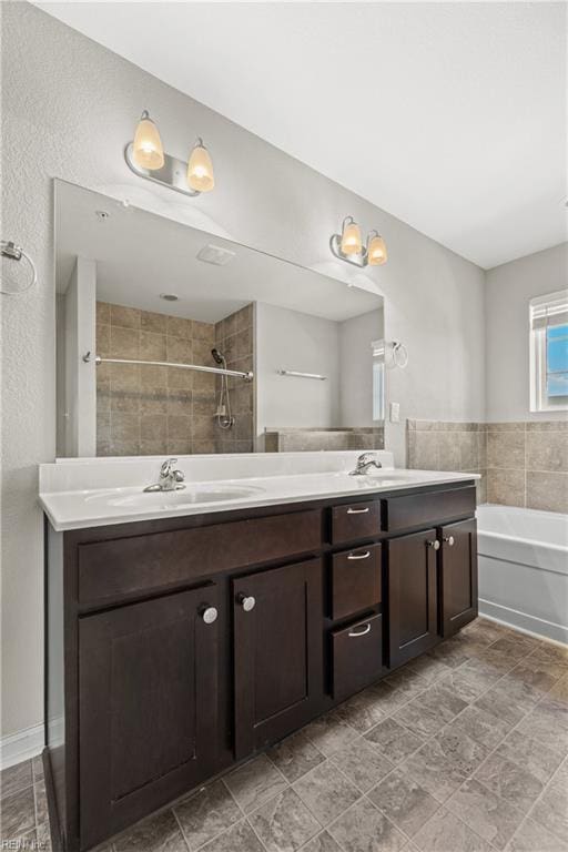 bathroom featuring vanity and independent shower and bath