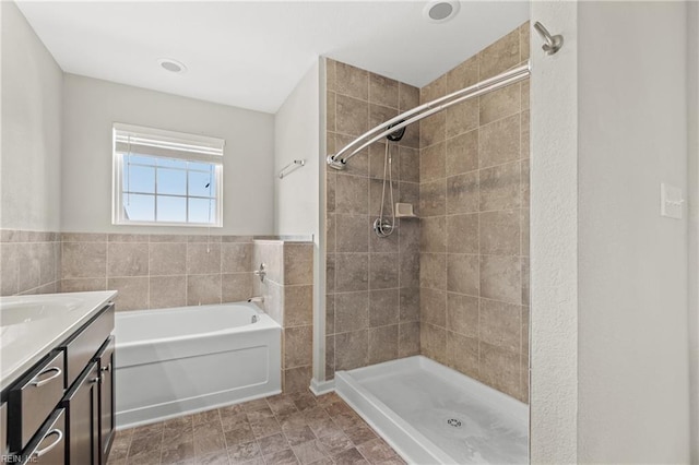 bathroom featuring shower with separate bathtub, vanity, and tile walls