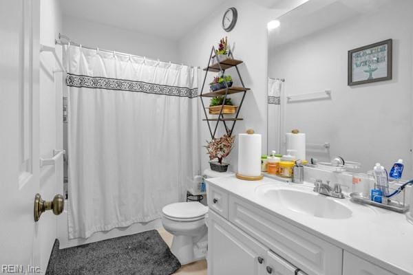 bathroom with a shower with shower curtain, vanity, and toilet