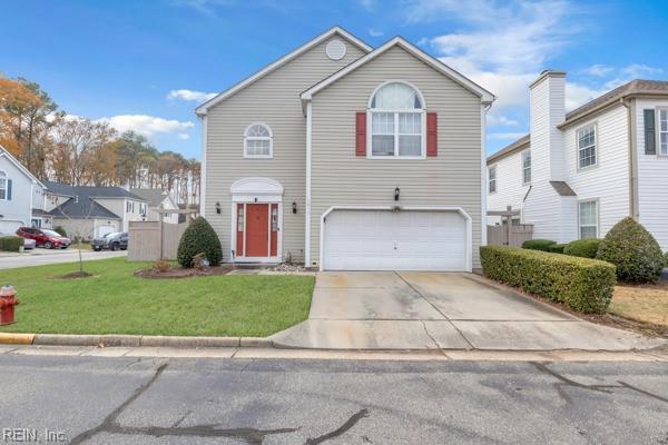 front facade with a garage and a front lawn