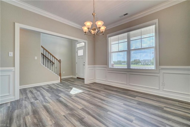 interior space featuring ornamental molding, hardwood / wood-style flooring, and a notable chandelier