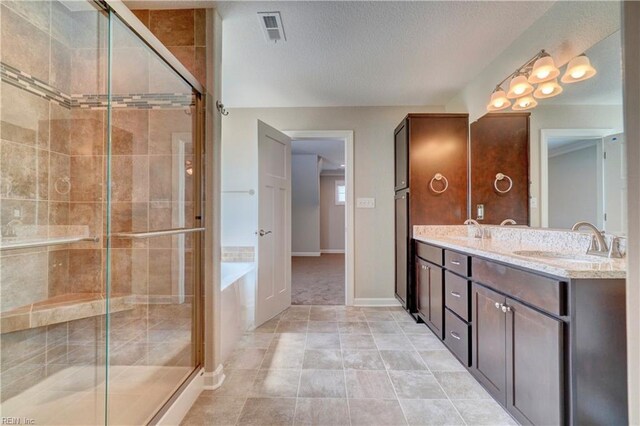 bathroom featuring vanity, a textured ceiling, and walk in shower