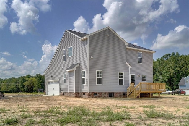 rear view of property featuring a wooden deck and a garage