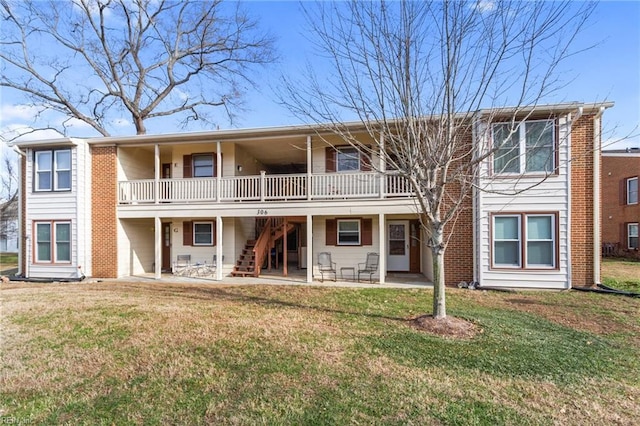 back of property with a lawn, a wooden deck, and a patio