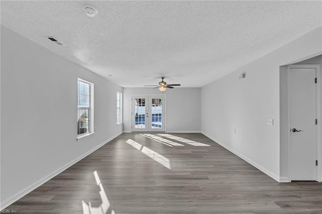 unfurnished living room featuring french doors, a textured ceiling, ceiling fan, and dark wood-type flooring