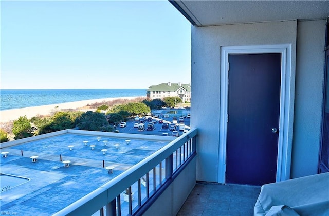 balcony featuring a water view and a beach view