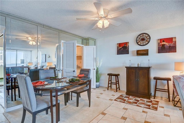 dining space with ceiling fan, light tile patterned flooring, and a textured ceiling