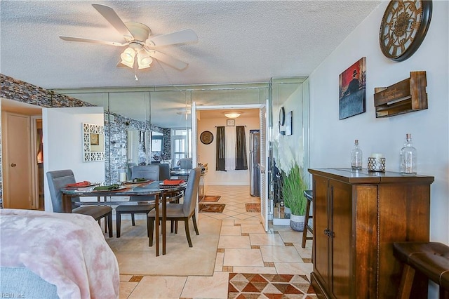 tiled dining room featuring ceiling fan and a textured ceiling