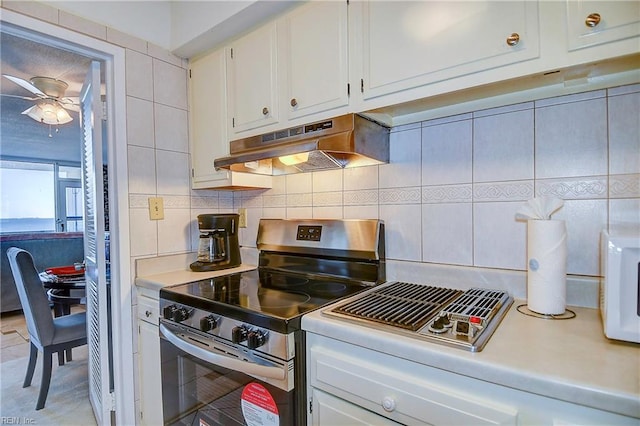 kitchen featuring white cabinets, decorative backsplash, ceiling fan, and stainless steel range with gas stovetop