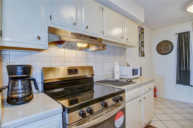 kitchen featuring decorative backsplash, stainless steel range, white cabinets, and light tile patterned floors