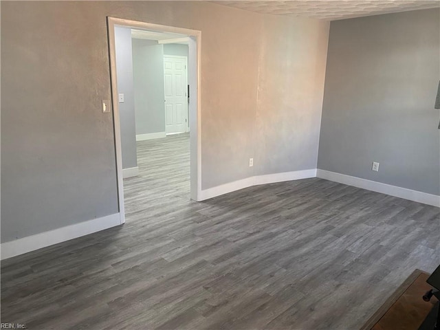 unfurnished room with dark wood-type flooring