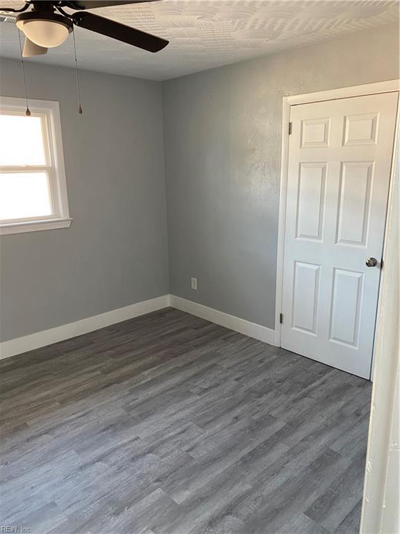 spare room with ceiling fan and dark hardwood / wood-style flooring