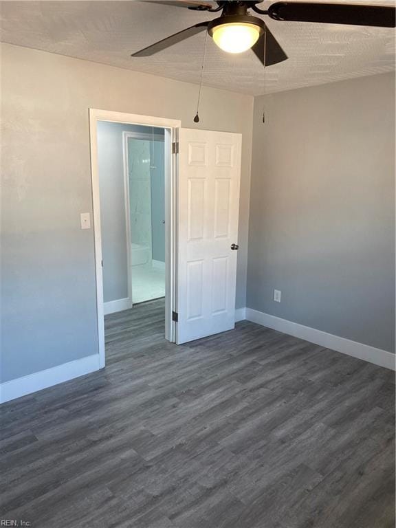 spare room featuring ceiling fan and dark wood-type flooring