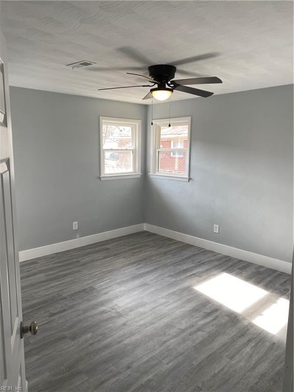 spare room featuring dark hardwood / wood-style floors and ceiling fan