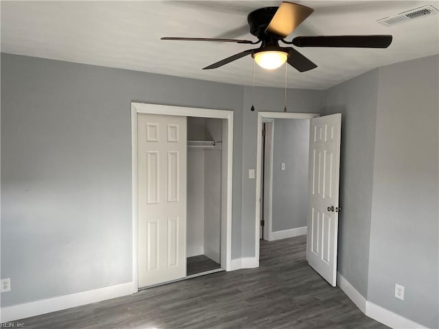 unfurnished bedroom featuring dark hardwood / wood-style flooring, a closet, and ceiling fan