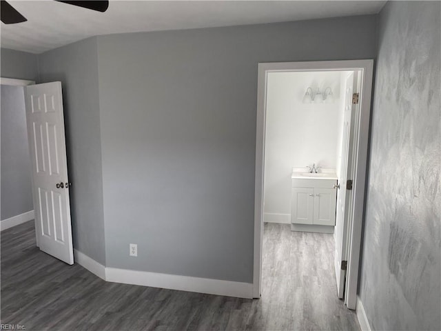 empty room with ceiling fan, dark wood-type flooring, and sink