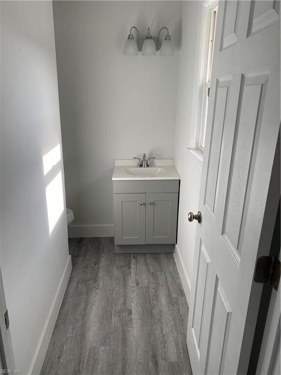 bathroom featuring hardwood / wood-style floors, vanity, and toilet