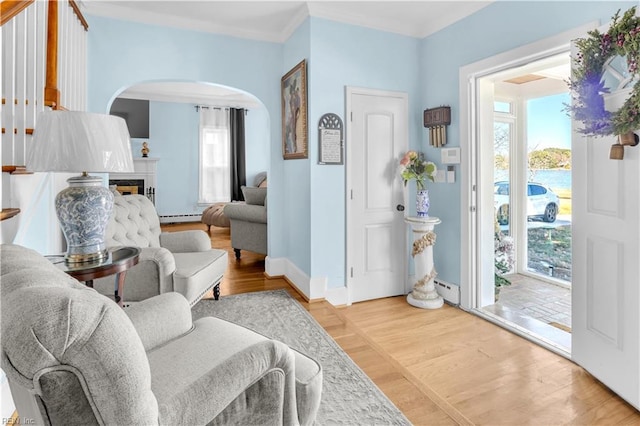 sitting room with hardwood / wood-style floors, baseboard heating, and crown molding