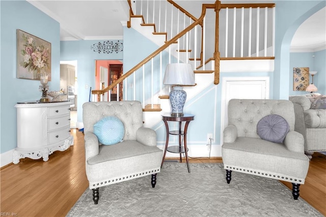 living area with hardwood / wood-style flooring and ornamental molding