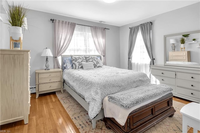 bedroom featuring a baseboard radiator and light wood-type flooring