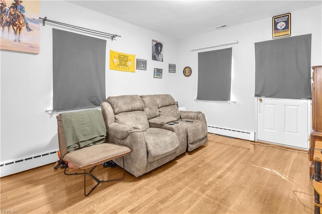 living room featuring wood-type flooring and a baseboard heating unit