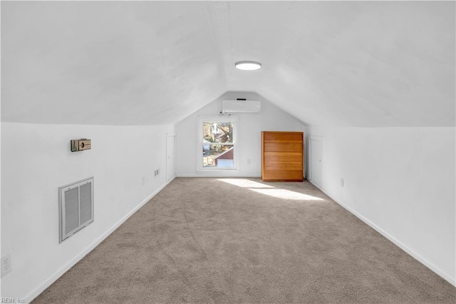 additional living space with an AC wall unit, light colored carpet, and lofted ceiling