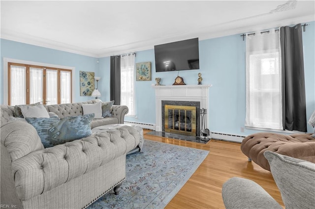 living room with wood-type flooring, crown molding, a high end fireplace, and a baseboard radiator