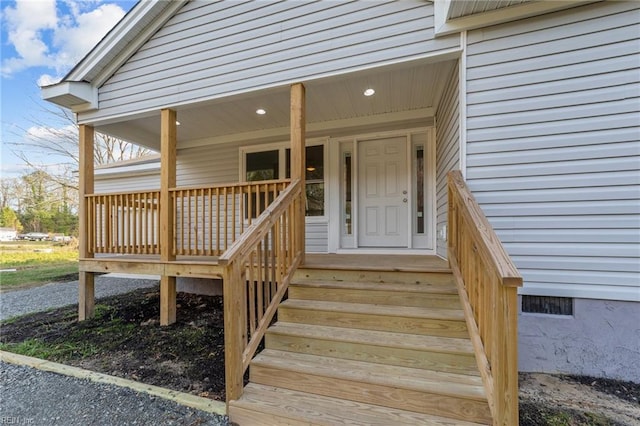 view of exterior entry featuring covered porch