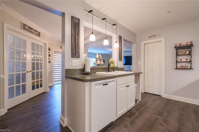 kitchen with sink, dark hardwood / wood-style flooring, white dishwasher, pendant lighting, and white cabinets