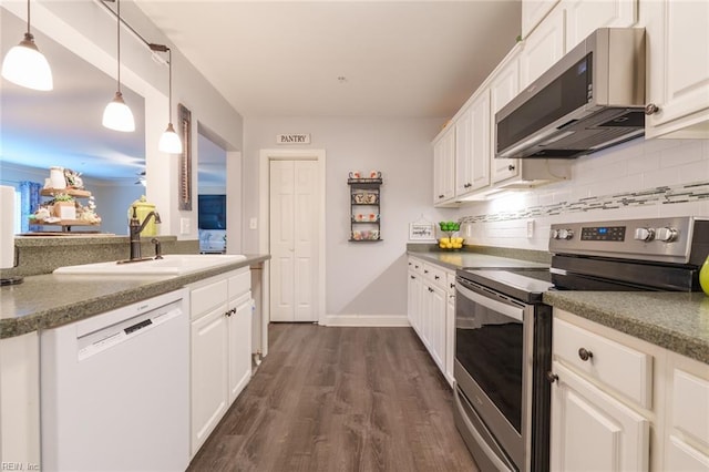 kitchen featuring white cabinetry, sink, hanging light fixtures, stainless steel appliances, and decorative backsplash