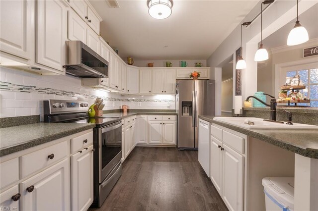 kitchen with white cabinets, stainless steel appliances, hanging light fixtures, and sink