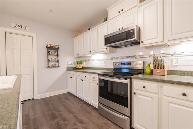 kitchen featuring white cabinets, decorative backsplash, stainless steel appliances, and dark wood-type flooring