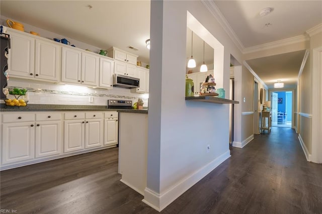 kitchen featuring hanging light fixtures, dark wood-type flooring, stainless steel appliances, crown molding, and white cabinets