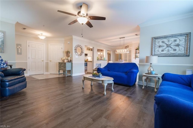 living room featuring dark wood-type flooring, ceiling fan, and crown molding