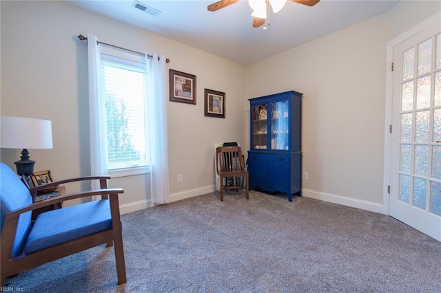 living area featuring ceiling fan, plenty of natural light, and carpet