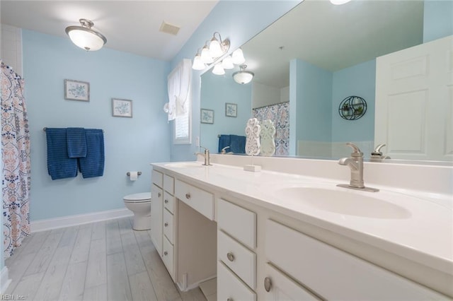 bathroom with hardwood / wood-style floors, vanity, and toilet